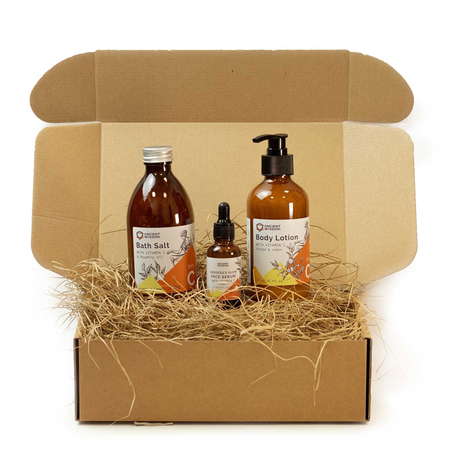 Set of skincare products including a bottle, jar, and lotion in a cardboard box with straw filler.