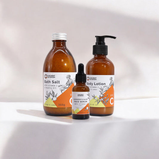 Set of bath salt, body lotion, and serum bottles with orange labels on a white background