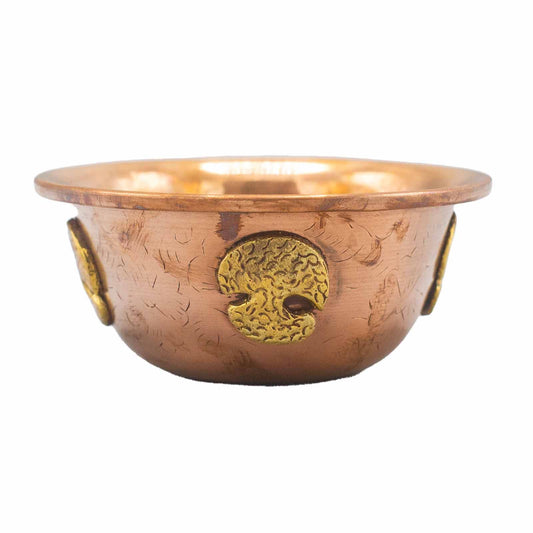 Copper bowl with embossed design on a white background