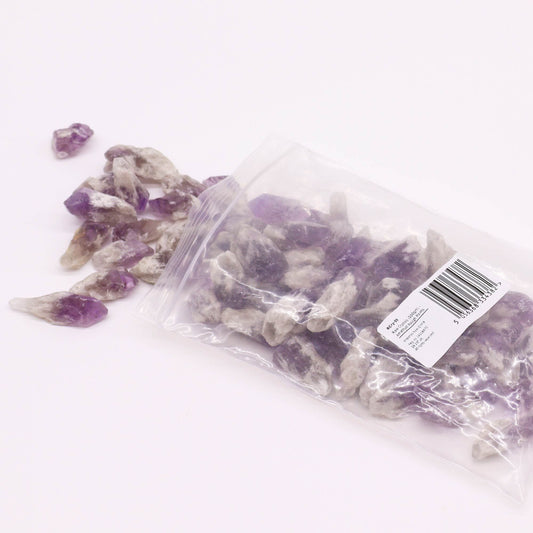Bag of purple and white crystals with a visible barcode label on a white background